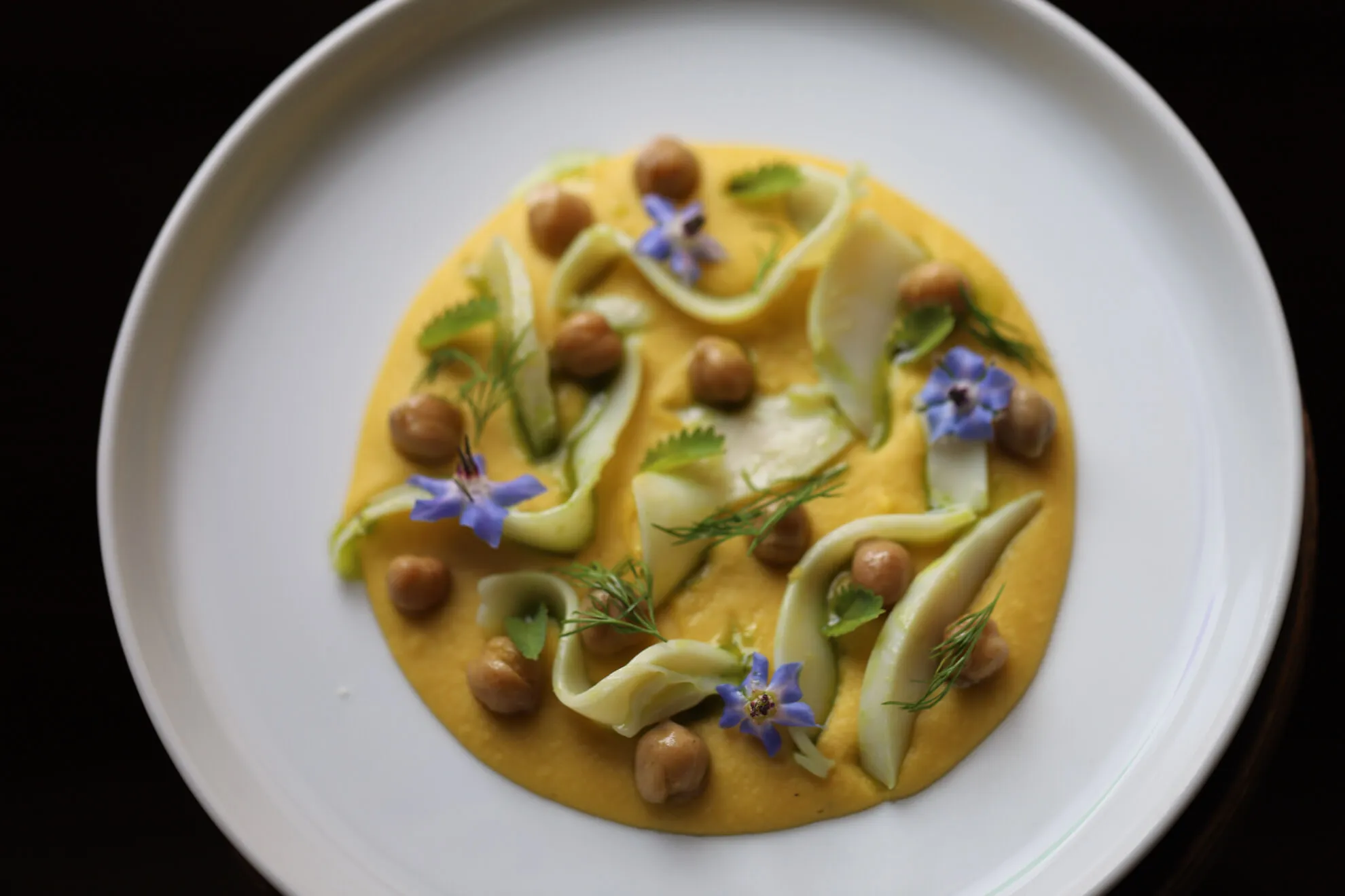 Piatto con ceci, fiori e erbe spontanee.